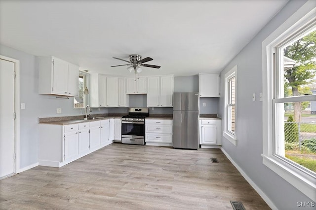 210 Essex St, Syracuse, NY 13204 - kitchen with appliances with stainless steel finishes, white cabinets, a ceiling fan, baseboards, and a sink