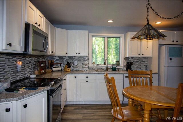 4748 Thrall Rd, Cambria, NY 14094 - kitchen featuring stainless steel microwave, black electric range, freestanding refrigerator, a sink, and white cabinets