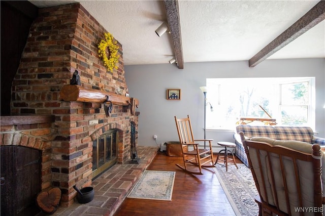 4748 Thrall Rd, Cambria, NY 14094 - living room featuring a fireplace, a textured ceiling, beam ceiling, and hardwood / wood-style floors