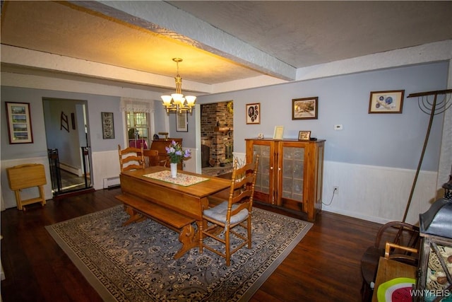 4748 Thrall Rd, Cambria, NY 14094 - dining area featuring a chandelier, beam ceiling, baseboard heating, wood finished floors, and a wainscoted wall