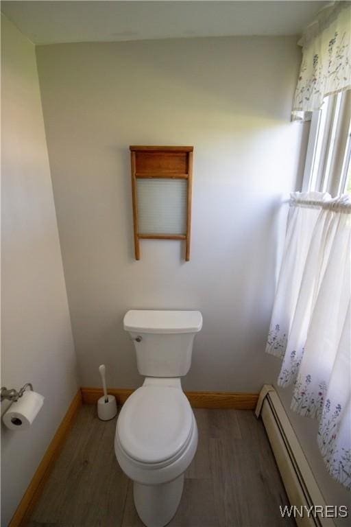 4748 Thrall Rd, Cambria, NY 14094 - bathroom featuring baseboard heating, wood finished floors, toilet, and baseboards