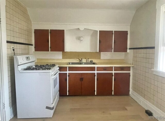 11 Verdun Ave, Buffalo, NY 14214 - kitchen featuring white gas stove, a sink, tile walls, light countertops, and light wood-style floors