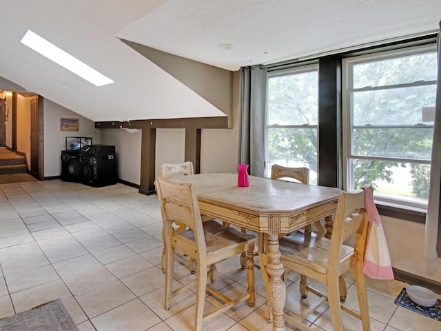 1459 Culver Rd, Rochester, NY 14609 - dining area featuring a skylight, vaulted ceiling, and light tile patterned flooring