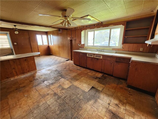 98 Gardeau St, Perry, NY 14530 - kitchen featuring wooden walls, light countertops, ceiling fan, under cabinet range hood, and a sink