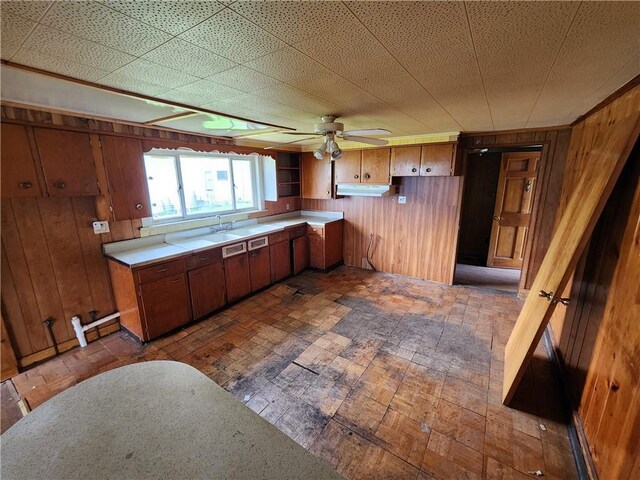 98 Gardeau St, Perry, NY 14530 - kitchen featuring a ceiling fan, light countertops, brown cabinets, wooden walls, and under cabinet range hood