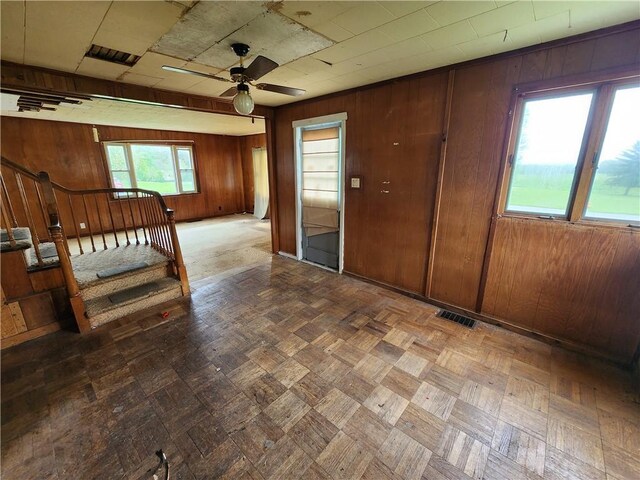 98 Gardeau St, Perry, NY 14530 - empty room with a ceiling fan, wood walls, and stairs
