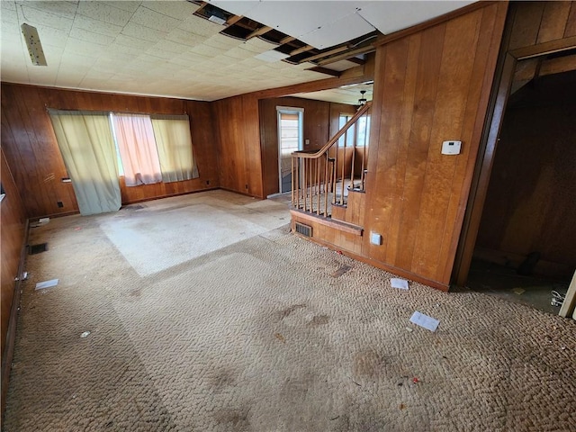 98 Gardeau St, Perry, NY 14530 - unfurnished living room featuring wooden walls, carpet, stairs, and baseboards