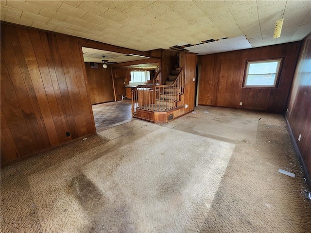 98 Gardeau St, Perry, NY 14530 - unfurnished living room featuring wood walls, stairway, plenty of natural light, carpet floors, and a ceiling fan