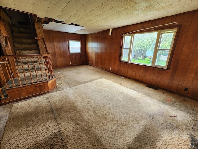 98 Gardeau St, Perry, NY 14530 - unfurnished living room featuring stairs, wooden walls, and carpet floors