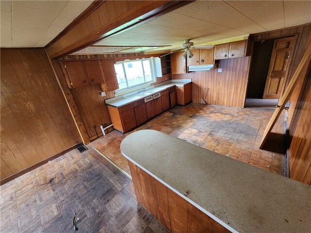 98 Gardeau St, Perry, NY 14530 - kitchen featuring wood walls, brown cabinetry, and light countertops