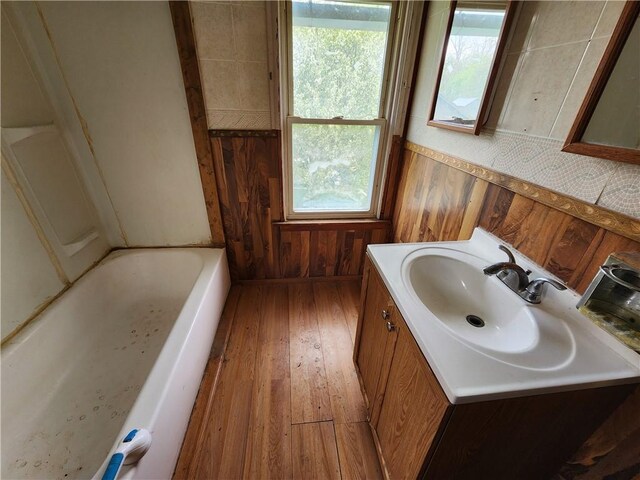 98 Gardeau St, Perry, NY 14530 - bathroom with a bathtub, vanity, wood-type flooring, plenty of natural light, and wood walls