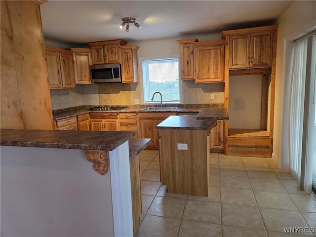 9600 Vermont View Rd, Machias, NY 14101 - kitchen featuring appliances with stainless steel finishes, a sink, dark countertops, decorative backsplash, and a breakfast bar