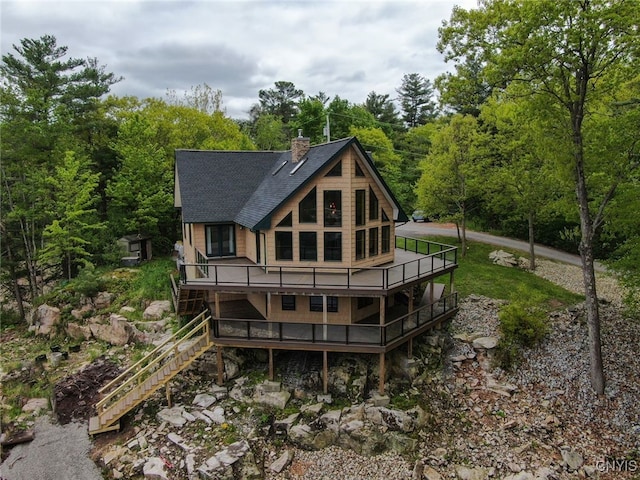 20172 Blue Heron Ln, Alexandria, NY 13607 - back of house with a shingled roof, a chimney, a wooden deck, stairs, and a forest view
