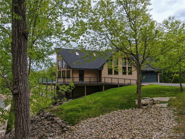 20172 Blue Heron Ln, Alexandria, NY 13607 - back of property with a shingled roof, a garage, a deck, and a lawn
