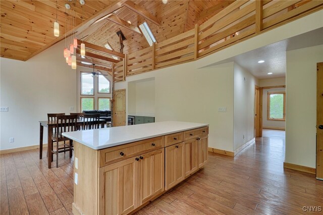 20172 Blue Heron Ln, Alexandria, NY 13607 - kitchen featuring baseboards, wooden ceiling with exposed beams, a skylight, light wood-style flooring, and a center island