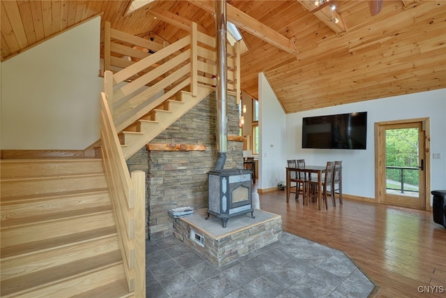20172 Blue Heron Ln, Alexandria, NY 13607 - living room featuring wooden ceiling with exposed beams, a wood stove, stairway, wood finished floors, and baseboards