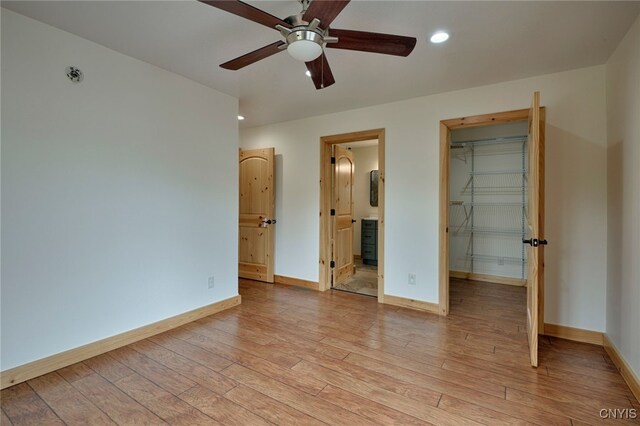 20172 Blue Heron Ln, Alexandria, NY 13607 - unfurnished bedroom featuring a walk in closet, light wood-type flooring, baseboards, a closet, and recessed lighting