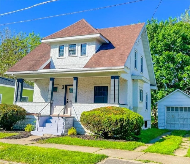 561 Post St, Elmira-City, NY 14904 - view of front of property with an outbuilding, a garage, a porch, roof with shingles, and stucco siding