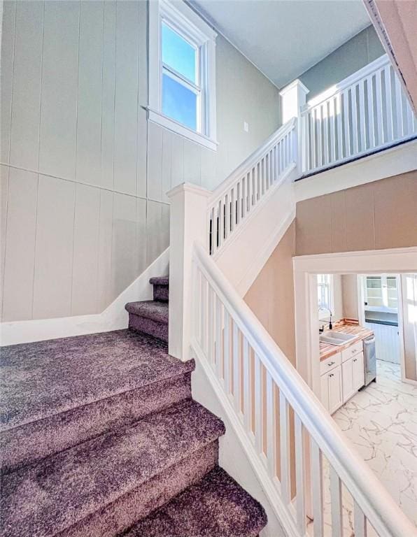 561 Post St, Elmira-City, NY 14904 - staircase featuring healthy amount of natural light, marble look tile flooring, and a high ceiling