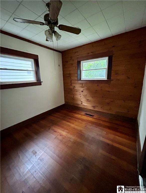 423 Plover St, Dunkirk-City, NY 14048 - spare room with wood walls, plenty of natural light, wood finished floors, ceiling fan, and baseboards