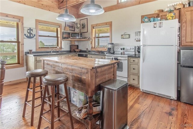 4146 Carleton Island Rd Unit 1, Cape Vincent, NY 13618 - kitchen featuring stainless steel appliances, light wood-type flooring, beamed ceiling, a kitchen bar, and a kitchen island