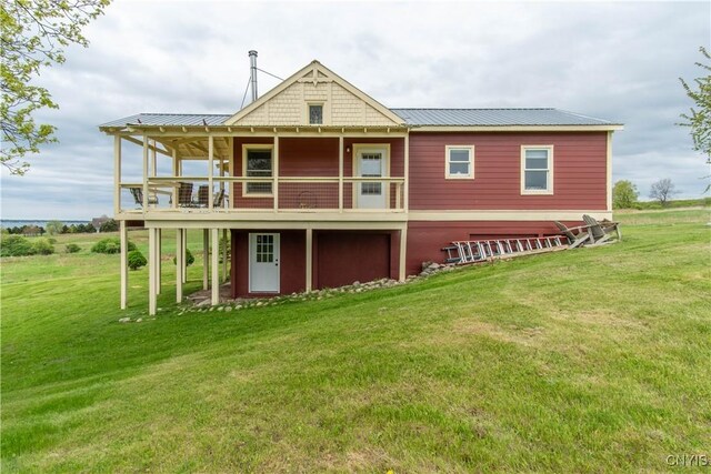 4146 Carleton Island Rd Unit 1, Cape Vincent, NY 13618 - back of property with a yard, metal roof, and a wooden deck