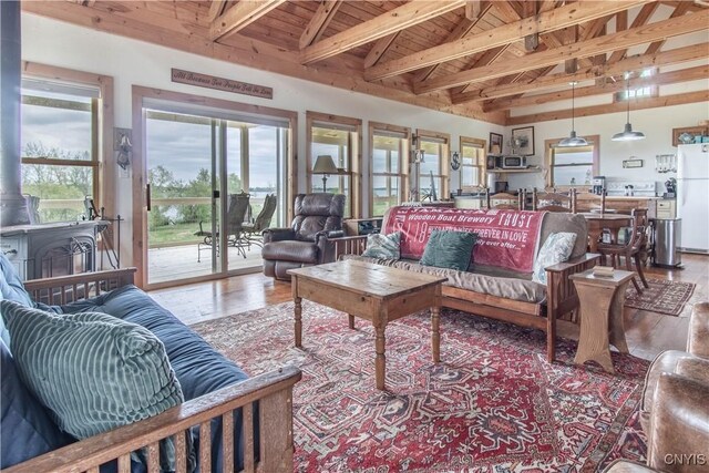 4146 Carleton Island Rd Unit 1, Cape Vincent, NY 13618 - living room featuring wood ceiling with exposed beams, wood finished floors, a wood stove, and high vaulted ceiling