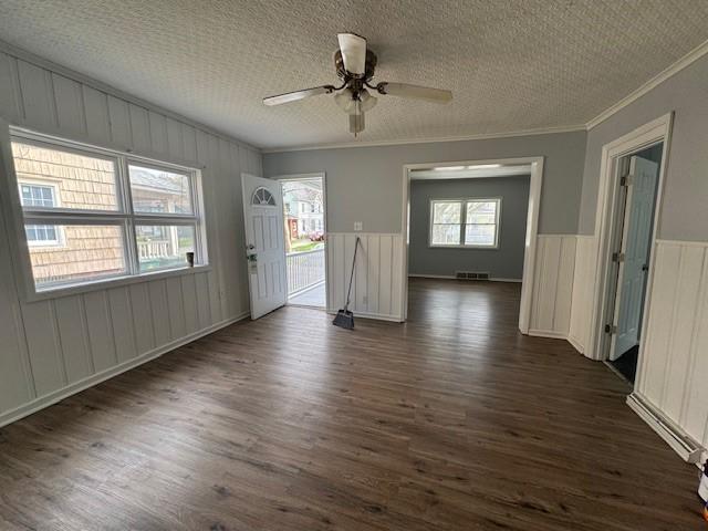 322 Grand Ave, Rochester, NY 14609 - unfurnished room featuring crown molding, dark wood-type flooring, a ceiling fan, a wainscoted wall, and a textured ceiling