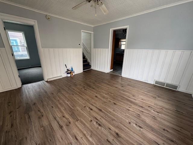 322 Grand Ave, Rochester, NY 14609 - spare room featuring wainscoting, a ceiling fan, stairs, dark wood finished floors, and ornamental molding