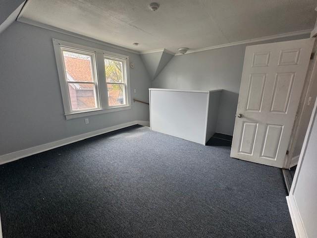 322 Grand Ave, Rochester, NY 14609 - additional living space with dark carpet, baseboards, and vaulted ceiling