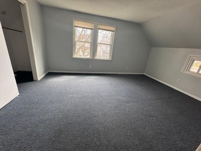 322 Grand Ave, Rochester, NY 14609 - additional living space featuring dark carpet, lofted ceiling, and baseboards