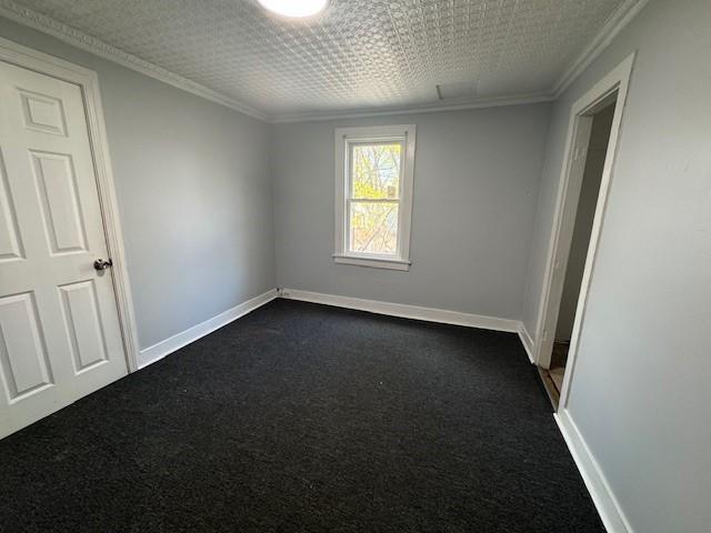 322 Grand Ave, Rochester, NY 14609 - empty room with baseboards, dark carpet, and ornamental molding