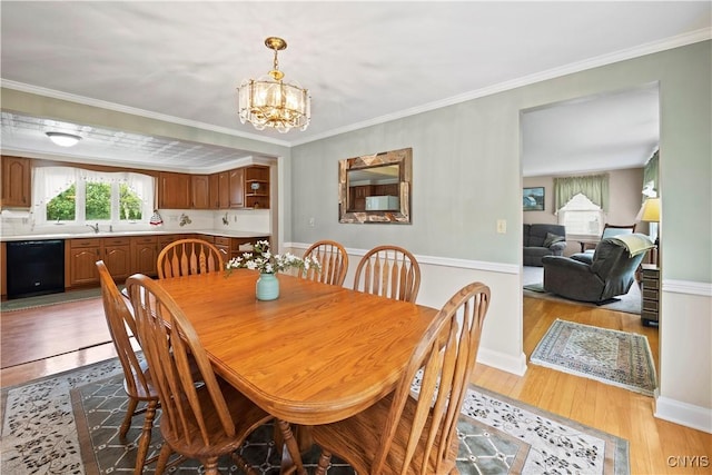 114 E Dauenhauer St, Manlius, NY 13057 - dining space with light wood-type flooring, a chandelier, ornamental molding, and baseboards