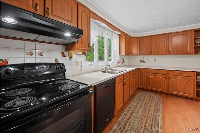 114 E Dauenhauer St, Manlius, NY 13057 - kitchen with black appliances, under cabinet range hood, a sink, and brown cabinetry