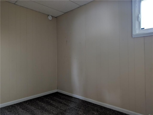 56 Aurora Ave, West Seneca, NY 14224 - unfurnished room with dark colored carpet, baseboards, wood walls, and a drop ceiling