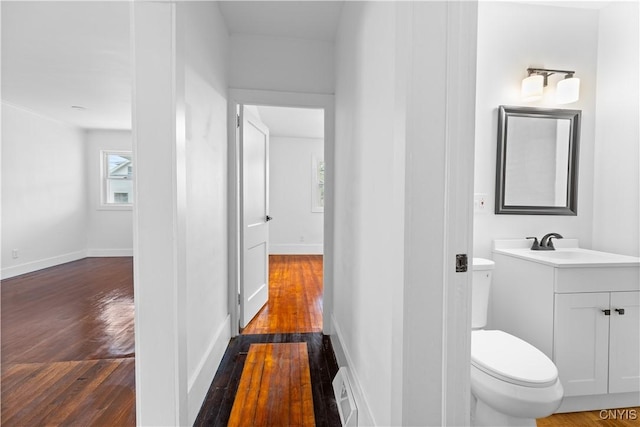 1310 Oak St, Utica, NY 13502 - bathroom featuring vanity, hardwood / wood-style floors, toilet, and baseboards