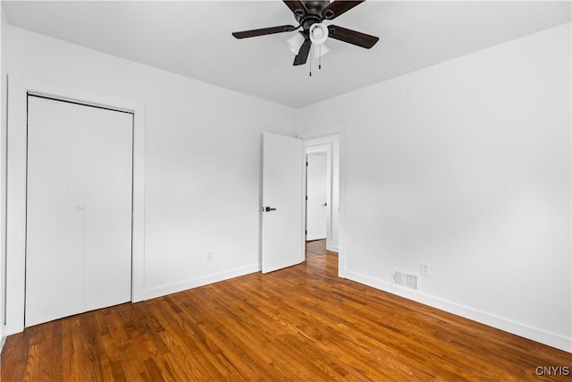 1310 Oak St, Utica, NY 13502 - unfurnished bedroom with wood finished floors, baseboards, a closet, and ceiling fan