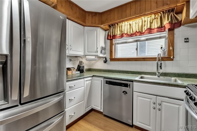 18 Spruce St, Lockport-City, NY 14094 - kitchen with appliances with stainless steel finishes, a sink, white cabinetry, backsplash, and light wood-type flooring