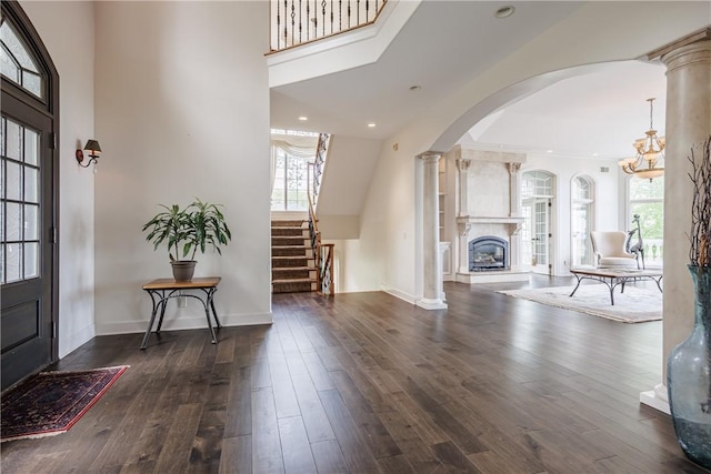 411 Sundance Trl, Webster, NY 14580 - foyer with hardwood / wood-style floors, a glass covered fireplace, stairway, baseboards, and arched walkways