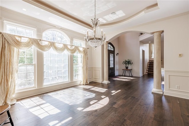 411 Sundance Trl, Webster, NY 14580 - unfurnished dining area featuring arched walkways, ornamental molding, plenty of natural light, wainscoting, and a decorative wall