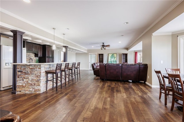 411 Sundance Trl, Webster, NY 14580 - living room with dark wood finished floors, ceiling fan, ornate columns, baseboards, and recessed lighting