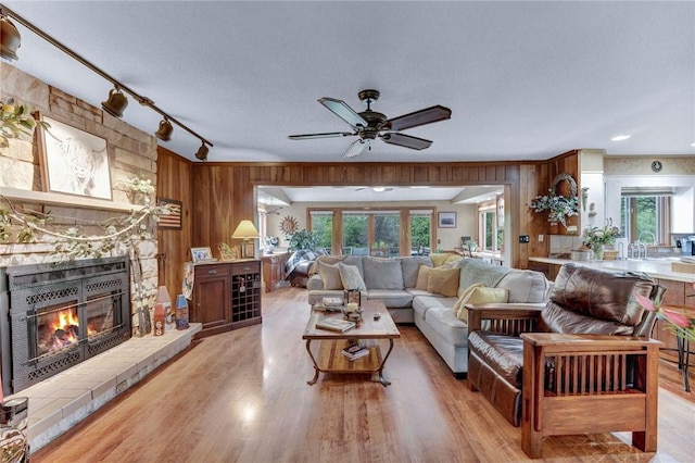 1338 Summit Rd, Foster Town, PA 16744 - living room with a fireplace, healthy amount of natural light, wood walls, a ceiling fan, and light wood finished floors