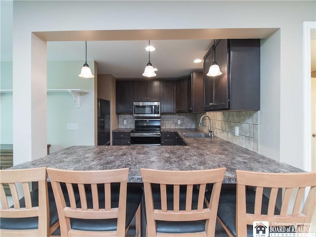 285 Porter Rd, Pomfret, NY 14063 - kitchen with appliances with stainless steel finishes, dark brown cabinets, a sink, backsplash, and dark countertops