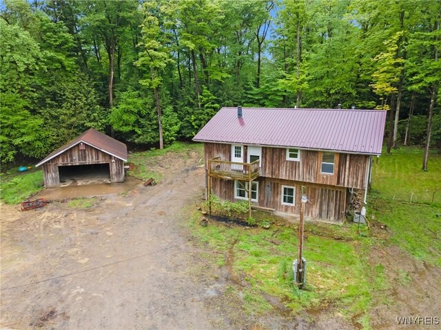 12353 Planck Rd, Perrysburg, NY 14129 - chalet / cabin with a garage, an outbuilding, metal roof, and a wooded view
