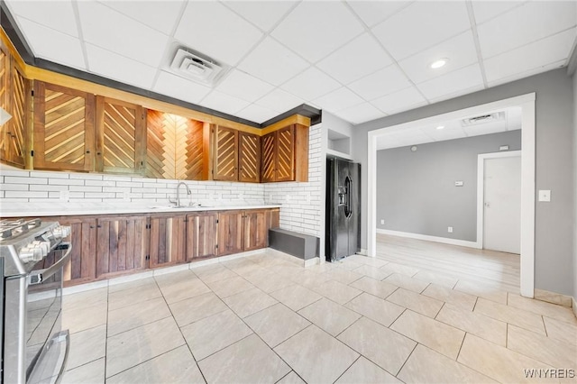 12353 Planck Rd, Perrysburg, NY 14129 - kitchen featuring stainless steel stove, black refrigerator with ice dispenser, a sink, light countertops, and a paneled ceiling