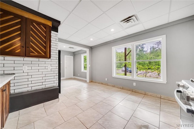 12353 Planck Rd, Perrysburg, NY 14129 - unfurnished living room featuring light tile patterned flooring, baseboards, and a drop ceiling