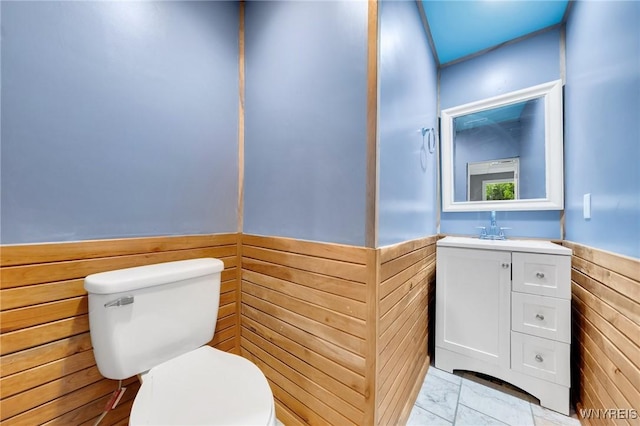 12353 Planck Rd, Perrysburg, NY 14129 - half bath with toilet, vanity, wainscoting, wooden walls, and marble finish flooring