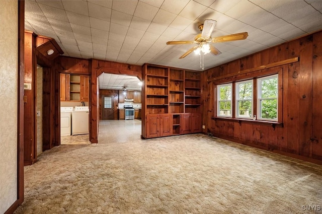 4064 Kayuta Ter, Forestport, NY 13438 - empty room with independent washer and dryer, wooden walls, arched walkways, a ceiling fan, and light colored carpet