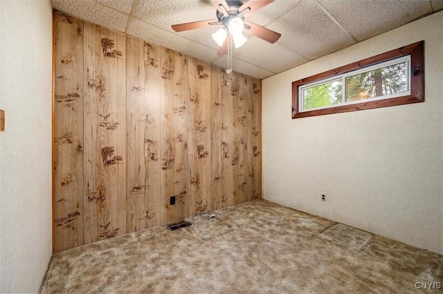 4064 Kayuta Ter, Forestport, NY 13438 - carpeted empty room featuring wood walls, a paneled ceiling, and ceiling fan