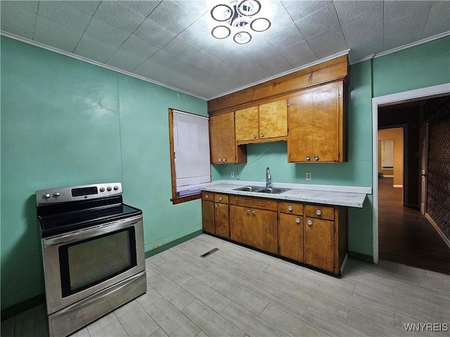 2207 Linwood Ave, Niagara Falls, NY 14305 - kitchen with electric range, a sink, ornamental molding, light countertops, and brown cabinets